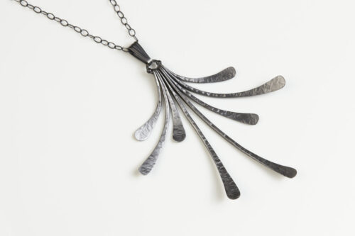 The Flash - Rustic Handmade Fan Necklace in Hammered Iron features 8 gently curving dangling iron elements hammered and faceted to reflect the light. The Flash - Rustic Handmade Fan Necklace in Hammered Iron is a beautifully understated yet striking iron statement necklace. The sterling silver chain matches the cool tones of the Iron perfectly. Light enough for every day, but sophisticated enough for a fancy night out, The Flash - Rustic Handmade Fan Necklace in Hammered Iron is a perfect gift for any occasion. A perfect 6th anniversary gift for her.