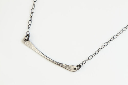 Simple Chic Curved Bar Necklace in Hammered Iron. The handmade, hammered, horizontal curved bar Necklace on a sterling silver chain reflect with lovely contrasting iron tones. Together, the Simple Chic Curved Bar Necklace in Hammered Iron is a simple necklace to wear everyday, or perfect for a fancy night on the town. A perfect iron 6th anniversary gift for her.