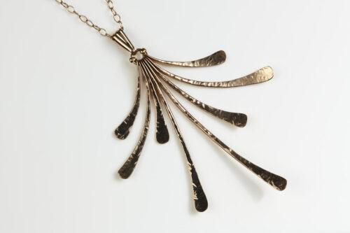 The Flash - Hammered Bronze Necklace displayed laying on a white background, Featuring 8 gently curving dangling bronze elements hammered and faceted to reflect the light. The Flash - Hammered Bronze Necklace is a beautifully understated yet striking statement necklace. The hammered bronze reflects the warm light in facets creating a lovely 8th anniversary gift for her. The gold fill chain matches the warm tones of the bronze perfectly. Light enough for every day, but sophisticated enough for a fancy night out, The Flash - Hammered Bronze Necklace are a perfect gift for any occasion. Bronze 8th anniversary gifts