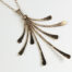 The Flash - Hammered Bronze Necklace displayed laying on a white background, Featuring 8 gently curving dangling bronze elements hammered and faceted to reflect the light. The Flash - Hammered Bronze Necklace is a beautifully understated yet striking statement necklace. The hammered bronze reflects the warm light in facets creating a lovely 8th anniversary gift for her. The gold fill chain matches the warm tones of the bronze perfectly. Light enough for every day, but sophisticated enough for a fancy night out, The Flash - Hammered Bronze Necklace are a perfect gift for any occasion. Bronze 8th anniversary gifts