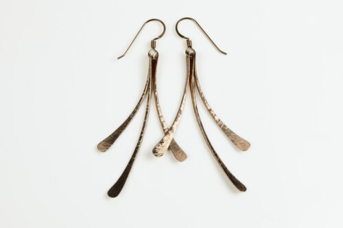 The Mini Flash - Hammered Bronze Earrings displayed laying on a white background, Featuring 3 gently curving dangling bronze elements hammered and faceted to reflect the light. The Mini Flash - Hammered Bronze Earrings are a beautifully understated yet striking pair of statement earrings. The hammered bronze reflects the warm light in facets creating a lovely 8th anniversary gift for her. The gold fill chain matches the warm tones of the bronze perfectly. Light enough for every day, but sophisticated enough for a fancy night out, The mini Flash - Hammered Bronze Earrings are a perfect gift for any occasion. Bronze 8th anniversary gifts