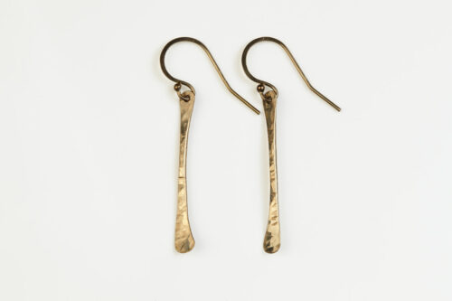 Simple Chic - Dainty Bronze earrings displayed laying on a white background. The uniquely minimalist Bronze bar dangle earrings display their uniquely hammered textures in the warm light. Gold filled ear wires match the warm tones of the copper. The rustic and simple earrings are perfect for everyday wear, or are elegant enough for a fancy night out. Bronze 8th anniversary gifts for her
