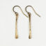 Simple Chic - Dainty Bronze earrings displayed laying on a white background. The uniquely minimalist Bronze bar dangle earrings display their uniquely hammered textures in the warm light. Gold filled ear wires match the warm tones of the copper. The rustic and simple earrings are perfect for everyday wear, or are elegant enough for a fancy night out. Bronze 8th anniversary gifts for her