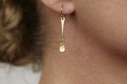 Simple Chic - Dainty Bronze earrings displayed laying on a white background. The uniquely minimalist Bronze bar dangle earrings display their uniquely hammered textures in the warm light. Gold filled ear wires match the warm tones of the copper. The rustic and simple earrings are perfect for everyday wear, or are elegant enough for a fancy night out. Bronze 8th anniversary gifts for her