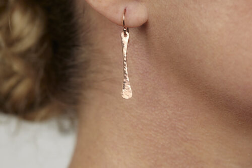 Simple Chic - Dainty Copper earrings displayed laying on a white background. The uniquely minimalist copper bar dangle earrings display their uniquely hammered textures in the warm light. Rose gold filled ear wires match the warm tones of the copper. Copper 7th anniversary gifts for wife