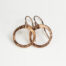 Tiny Zen Circle - Chunky Hoop Earrings in Copper displayed nestled together on a white background, these small drop hoop earrings are hand hammered creating a lovely faceted surface that highlights the contrasting light and reflectivity of these simple and beautiful handmade drop hoop earrings. Copper anniversary gifts for her