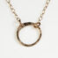 The Tiny Zen Circle - Bronze Simple Circle Necklace. Shown on a white background, a simple hammered bronze circle embodying the Japanese concept of Enso, the Tiny Zen Circle - Bronze Simple Circle Necklace a beautifully understated yet striking necklace. The hammered bronze reflects the warm light in facets creating a lovely and simple everyday necklace. The gold fill chain matches the warm tones of the bronze perfectly. Small and light enough for every day, but sophisticated enough for a fancy night out, The Tiny Zen Circle - Bronze Simple Circle Necklace is a perfect gift for every occasion and makes a lovely Bronze 8th anniversary gifts for her