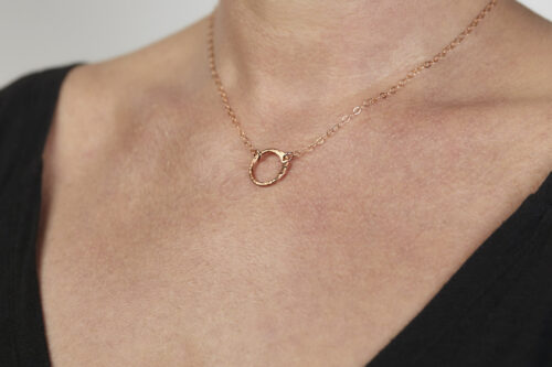 The Tiny Zen Circle - Simple Copper Circle Necklace. Shown being worn by a woman, a simple hammered copper circle embodying the Japanese concept of Enso, the Tiny Zen Circle - Simple Copper Circle Necklace a beautifully understated yet striking necklace. The hammered copper reflects the warm light in facets creating a lovely and simple everyday necklace. The rose gold fill chain matches the warm tones of the copper perfectly. Small and light enough for every day, but sophisticated enough for a fancy night out, The Tiny Zen Circle - Simple Copper Circle Necklace is a perfect gift for every occasion and makes a lovely copper 7th anniversary gift for her