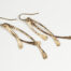 Trio Elegant Dangle Earrings in Bronze displayed laying on a white background. The three delicately curved and hammered bronze dangles reflect the light in facets. The gold fill ear wires match the warm tones of the bronze perfectly. Small and light enough for every day, but sophisticated enough for a fancy night out, the Trio Dangle Earrings in Bronze are perfect for every occasion. 8th anniversary gifts for her