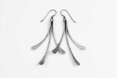 The Mini Flash - long dangle Earrings in hammered iron feature 3 gently curving dangling iron elements hammered and faceted to reflect the light. The Mini Flash - long dangle earrings are beautifully understated yet striking iron statement earrings. The sterling silver chain matches the iron perfectly. Light enough for every day, but sophisticated enough for a fancy night out, The Mini Flash - Long Dangle Earrings in hammered iron are a perfect 6th anniversary gift.