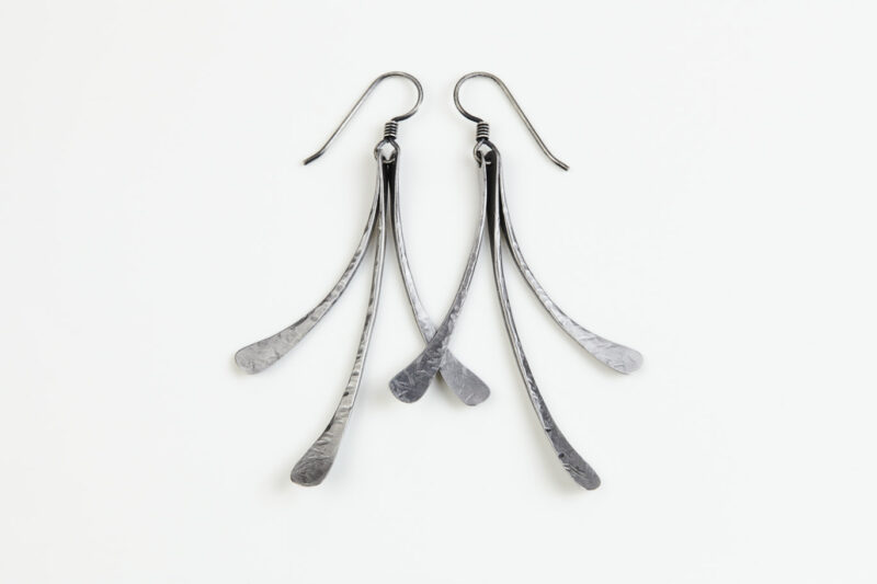 The Mini Flash - long dangle Earrings in hammered iron feature 3 gently curving dangling iron elements hammered and faceted to reflect the light. The Mini Flash - long dangle earrings are beautifully understated yet striking iron statement earrings. The sterling silver chain matches the iron perfectly. Light enough for every day, but sophisticated enough for a fancy night out, The Mini Flash - Long Dangle Earrings in hammered iron are a perfect 6th anniversary gift.
