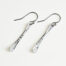 Simple Chic - Aluminum Bar earrings displayed laying on a white background. The uniquely minimalist aluminum bar dangle earrings display their uniquely hammered textures in the warm light. Sterling silver ear wires match the aluminum. These rustic and simple earrings are perfect for everyday wear, or are elegant enough for a fancy night out.