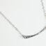 Simple Chic - Aluminum Bar Necklace displayed laying on a white background. The uniquely minimalist Aluminum curved bar necklace displays its hand forged textures in the warm light. The sterling silver chain matches the cool tones of the Aluminum showcasing its simple elegance.