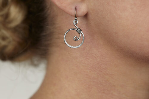 The Tiny Swirls - Spiral Hoop Earrings in Iron. These iron drop hoop spiral earrings have a wire wrapped iron detail that creates the closed circle of the hoop creating a tiny spiral inside the hoops that provide the cute focal point of the earrings. Delicately hammered facets reflect the light of the hammered iron. The sterling silver ear wires match the polished iron perfectly. Small and light enough for every day, but sophisticated enough for a fancy night out, the Tiny Swirls - Spiral Hoop Earrings in iron are perfect for every occasion and make a lovely 6th anniversary gift for her