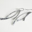 Trio Aluminum Boho Earrings displayed laying on a white background. The three delicately curved and hammered aluminum dangles reflect the light in facets. The sterling silver ear wires match the cool tones of the aluminum perfectly. Small and light enough for every day, but sophisticated enough for a fancy night out, the Trio Aluminum Boho Earrings are perfect for every occasion.