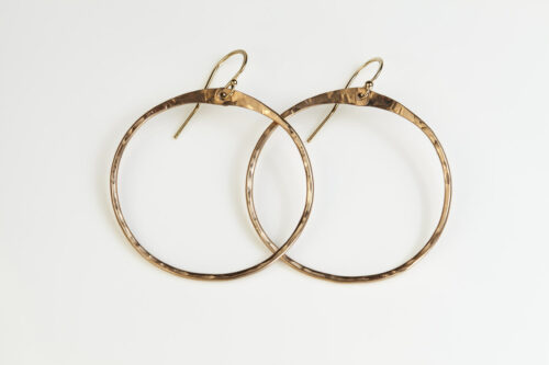 The Zen Circle - Chunky Hoops Bronze Earrings. Displayed on a white background, Feature simple hammered bronze circles embodying the Japanese concept of Enso, the Zen Circle - bronze hammered hoop earrings are beautifully understated yet striking earrings. The hammered bronze reflects the warm light in facets creating a lovely and simple everyday earrings. The gold fill ear wires match the warm tones of the bronze perfectly. Small and light enough for every day, but sophisticated enough for a fancy night out, The Zen Circle - Chunky Hoops Bronze Earrings are a perfect gift for any occasion. Bronze 8th anniversary gifts